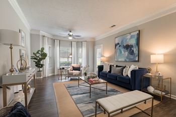 Living room with ample seating and bay windows at Chace Lake Villas apartments for rent